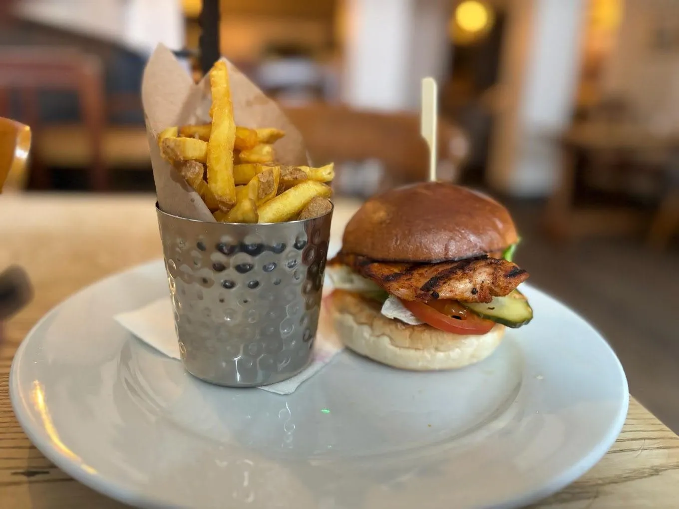 Burger and chips served at a wooden table in The Volley